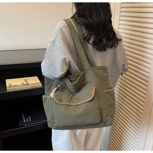 Detail of olive corduroy tote bag showing multiple pockets and vintage striped texture