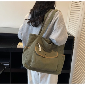 Detail of army green corduroy tote bag featuring functional front pockets and textured fabric