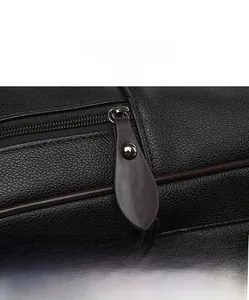 Détail de la fermeture éclair en métal et languette en cuir sur sac noir