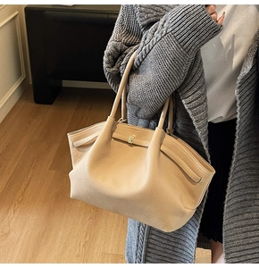 Détail d'un grand sac cabas beige avec texture cuir grainé et garnitures dorées