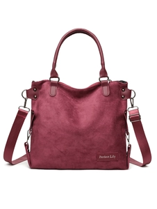 Detail of burgundy suede tote bag featuring rigid handles and Perfect Lily logo patch