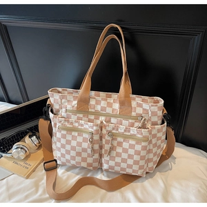 Detailed close-up of checkered corduroy tote bag with multiple pockets and wide strap