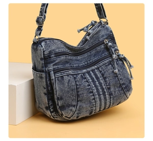 Détail du sac bandoulière en denim bleu délavé à poches multiples et bandoulière réglable
