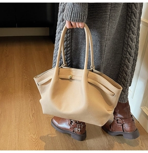 Détail du sac cabas en cuir beige avec boucle dorée et texture grainée de luxe