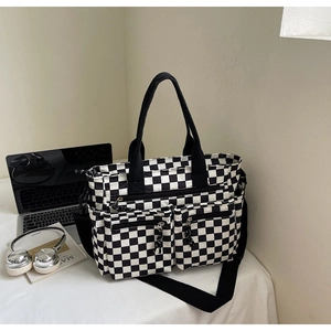 Detail of checkered tote bag with two front zipper pockets and adjustable strap