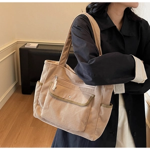 Detailed view of light brown corduroy tote bag with front pockets and soft texture