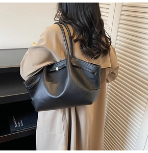 Détail d'un cabas noir en cuir grainé avec boucle métallique et bandoulière réglable