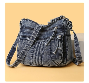 Détails d'un sac bandoulière en denim à plusieurs poches avec fermetures éclair et sangle