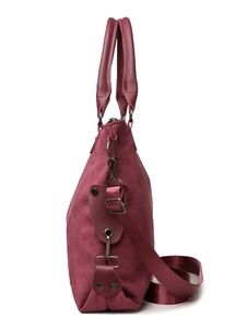 Detailed side view of wine red suede tote bag with leather handle and woven strap