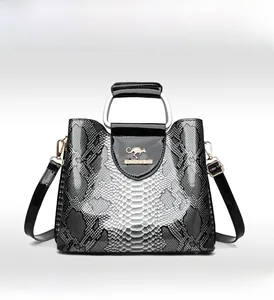 Detail of snake print pattern with golden kangaroo logo on elegant women's handbag