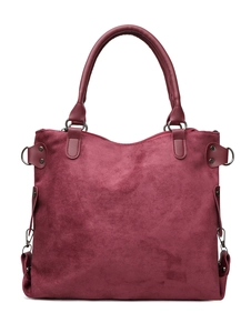 Detailed macro view of burgundy suede tote bag with metal zipper and rivet accents
