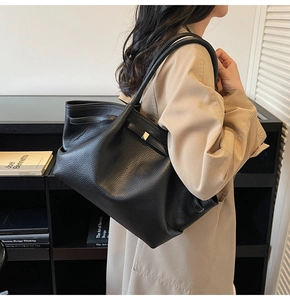Détail du sac cabas en cuir grainé noir avec boucle métallique et style minimaliste