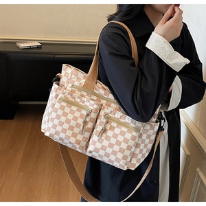 Detail view of pink and white checkered tote bag with multiple front zipper pockets
