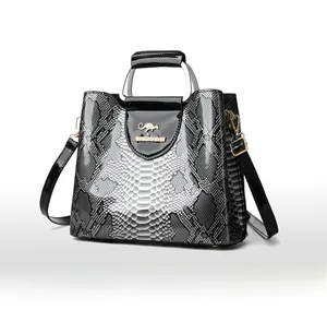 Detail of elegant black and white snake pattern handbag with golden kangaroo logo