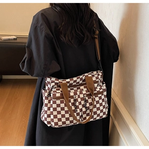 Detailed view of the checkered tote bag with front zipper pockets and adjustable straps
