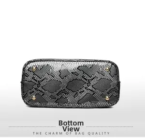Detailed view of the handbag base featuring snake print and four protective gold metal feet