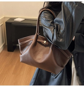 Détail d'un grand cabas en cuir grainé marron foncé avec une texture souple et douce