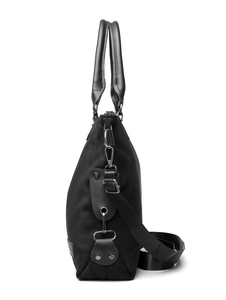 Side view of black canvas tote bag with leather handles and adjustable shoulder strap