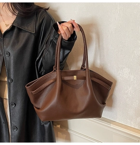 Gros plan du sac en cuir marron à motif litchi avec des détails plissés élégants