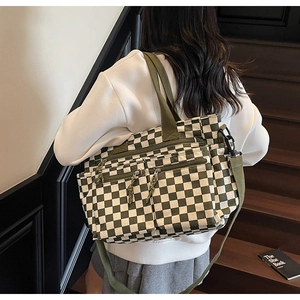 Detail of checkered tote bag showing multi-pocket design and green canvas texture