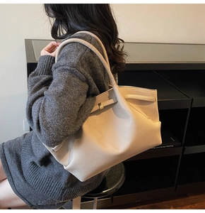 Détail du grand sac cabas en cuir crème avec texture grainée et boucle en métal