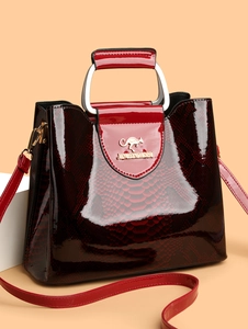 Close-up of dark red snakeskin pattern handbag with glossy finish and silver metal handle