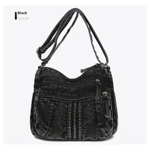 Détail frontal du sac bandoulière en denim noir avec plusieurs poches zippées pratiques