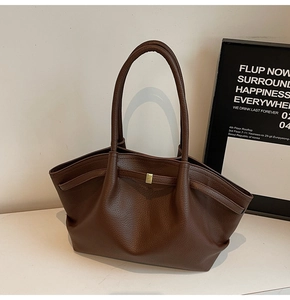 Détail du sac cabas marron foncé montrant le cuir grainé et la boucle carrée dorée