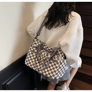 Detailed view of checkered tote bag with multiple pockets and durable canvas texture
