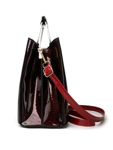 Macro view of gradient patent leather texture and gold hardware on tote bag