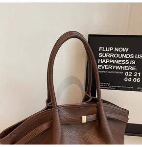 Détail du sac cabas en cuir grainé marron foncé avec boucle dorée et grandes anses