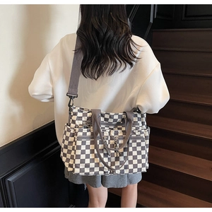 Rear view of a model wearing the checkered tote bag with adjustable shoulder straps