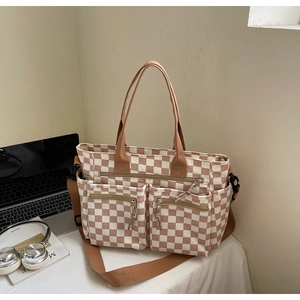 Detail of checkerboard tote bag with dual front zipper pockets and adjustable strap