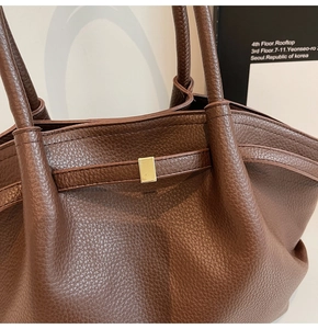 Détail du cabas en cuir marron à motif litchi avec d'élégantes finitions dorées