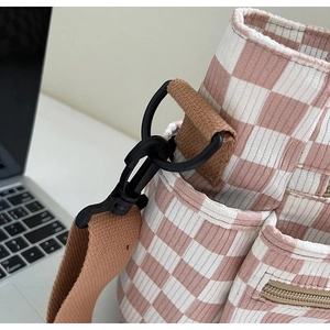 Detail of pink checkerboard corduroy tote bag showing metal D-ring and zipper pocket