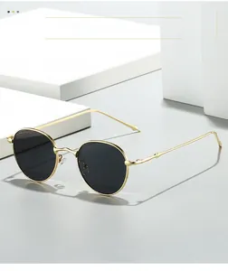 Close-up of golden wavy branch-textured temples on stylish oval frame sunglasses