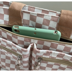 Detailed view of pink checkered corduroy tote bag showing multiple pockets and tablet capacity