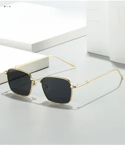 Detail of vintage square sunglasses with textured gold metal frames and grey lenses