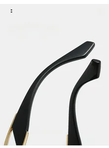 Detail view of glossy black curved temple arms with elegant gold metal decorative trim