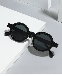 Detail of round sunglasses featuring unique vertical textured frames and dark grey lenses