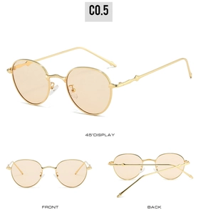 Macro detail of oval sunglasses with bamboo style gold metal frame and amber lenses