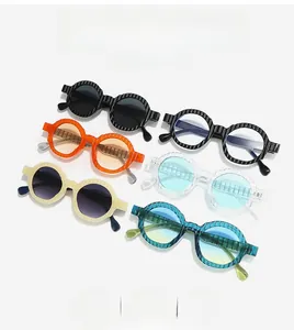 Detail of retro round sunglasses showing vertical ribbed relief on colored resin frames