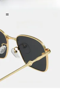 Detailed macro view of gold metal sunglasses frame with unique bamboo-style temple design