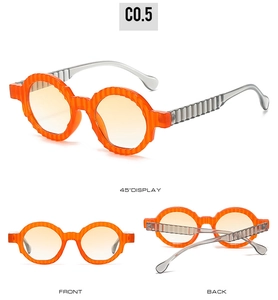 Detail view of round sunglasses featuring orange striped frame and gradient lenses