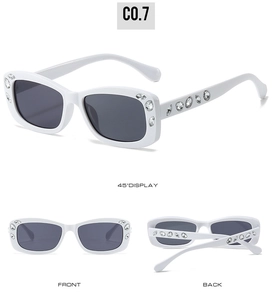 Detail view of white oval sunglasses with sparkling rhinestones and dark lenses