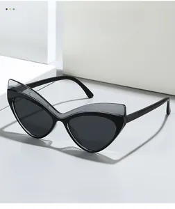 Detailed macro shot of modern cat eye sunglasses with layered gray frame and black lenses