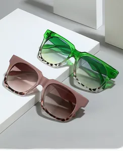 Detailed view of oversized square sunglasses in green and pink on geometric steps