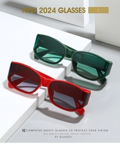 Macro detail of red and dark green wide-frame computer glasses on white stone blocks