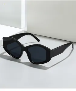 Detail einer schwarzen Cat-Eye-Sonnenbrille auf einem weißen geometrischen Sockel