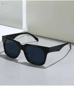 Close-up of black oversize square sunglasses with dark blue lenses on geometric blocks